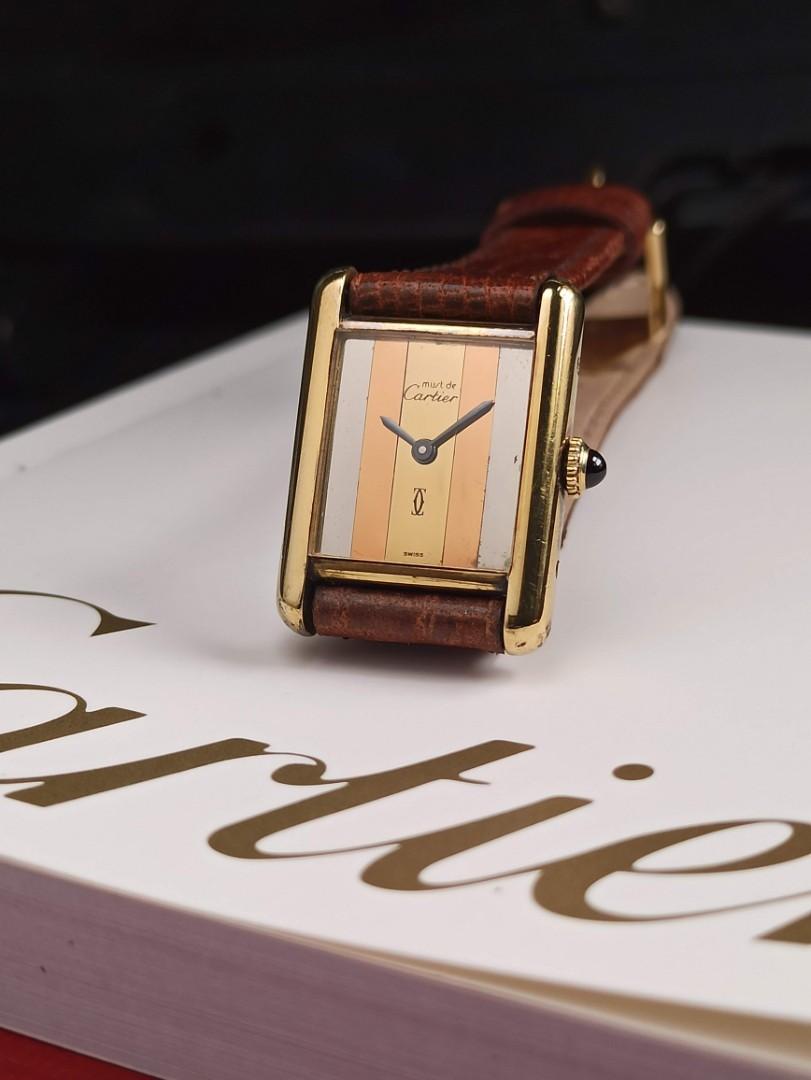 Cartier Tank Must De Cartier Trilogy dial 1980 model Silver PVD Gold accents Quartz movement Luxury timepiece Vintage watch Sterling silver case Yellow gold coating Brown leather strap Elegant design Classic watch High-quality craftsmanship Timeless style Beat The Waitlist Watch accessories Watch box Presentation papers Collector's item